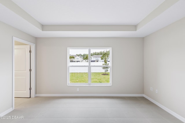 spare room with light tile patterned flooring and baseboards