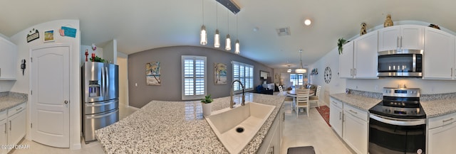 kitchen featuring stainless steel appliances, white cabinetry, sink, and pendant lighting