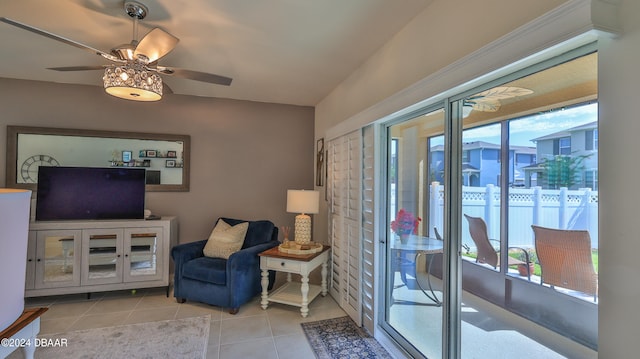 living area with light tile patterned floors and ceiling fan