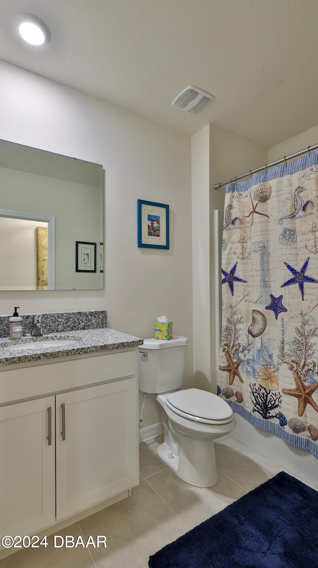 bathroom with toilet, vanity, tile patterned floors, and walk in shower