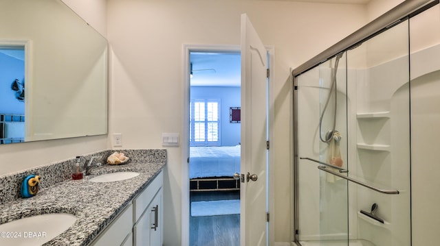 bathroom with hardwood / wood-style flooring, a shower with door, and vanity