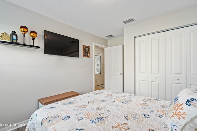 bedroom with a textured ceiling and a closet