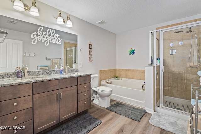 full bathroom featuring vanity, plus walk in shower, a textured ceiling, and hardwood / wood-style flooring