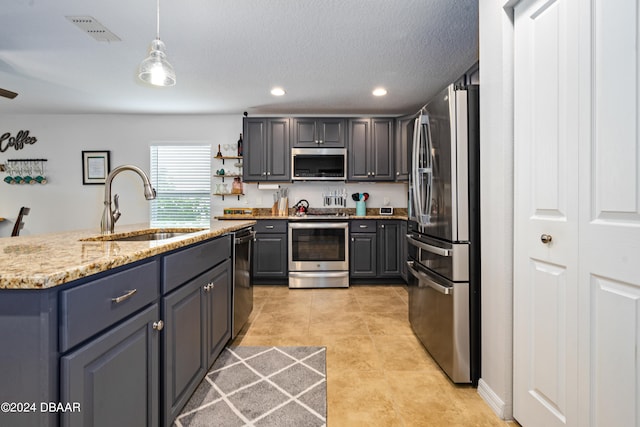 kitchen featuring gray cabinets, stainless steel appliances, hanging light fixtures, and sink