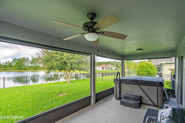 sunroom featuring a jacuzzi, a water view, and ceiling fan