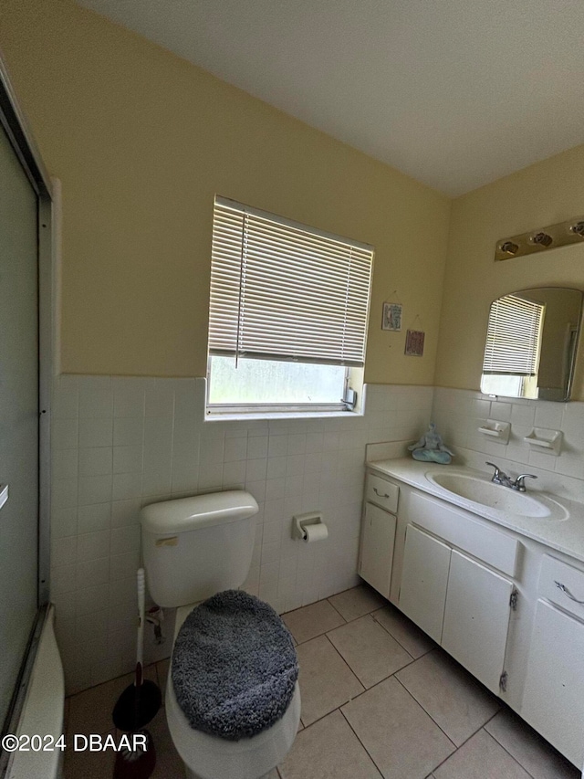 bathroom featuring toilet, vanity, tile walls, and tile patterned floors