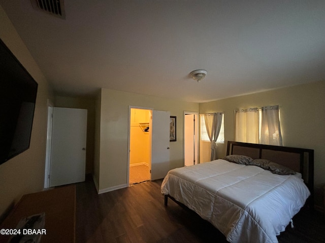 bedroom with wood-type flooring, a closet, and a spacious closet