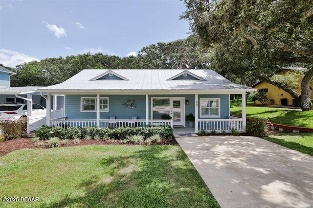 bungalow-style house featuring covered porch and a front lawn