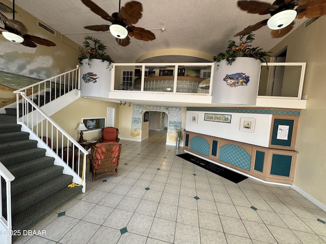 interior space featuring ceiling fan, vaulted ceiling, and a textured ceiling