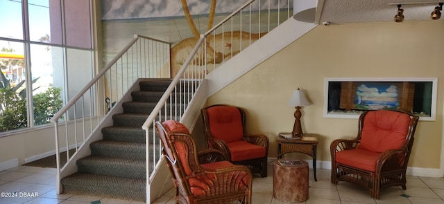 staircase with rail lighting, tile patterned floors, and a textured ceiling