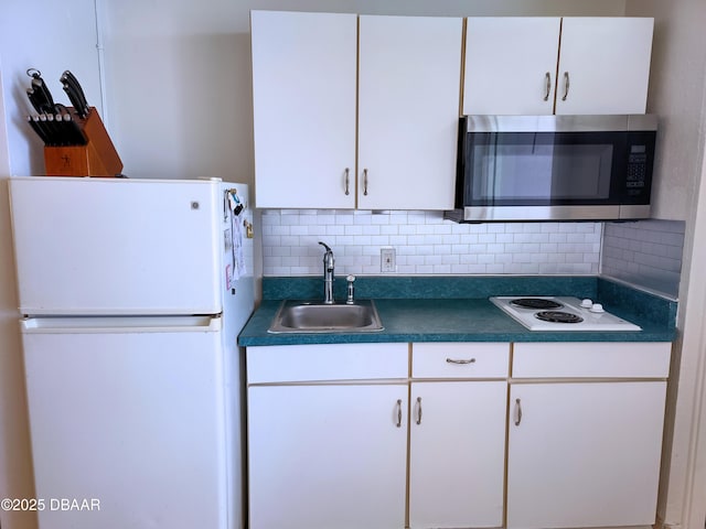 kitchen with backsplash, white appliances, sink, and white cabinets