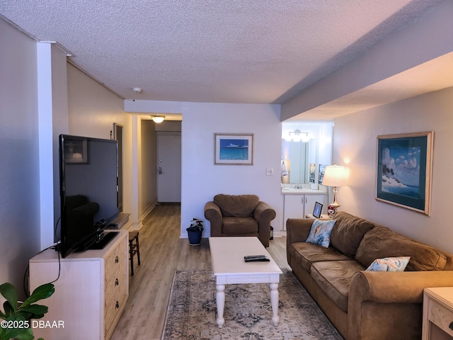 living room featuring a textured ceiling and light hardwood / wood-style floors