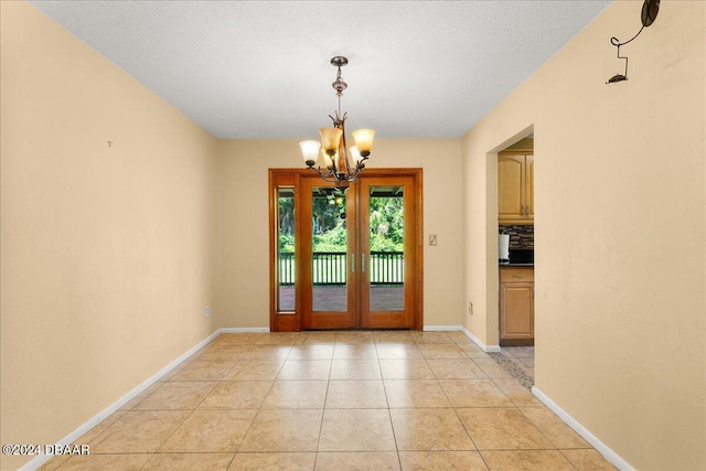 doorway featuring a chandelier, a textured ceiling, and light tile patterned floors