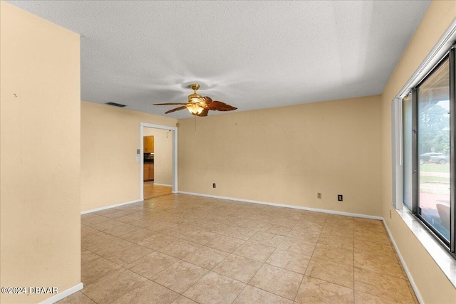 empty room with a textured ceiling and ceiling fan