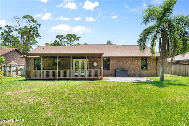 back of property with a lawn, french doors, and a patio area