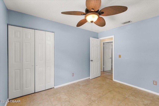 unfurnished bedroom featuring ceiling fan, a textured ceiling, and a closet