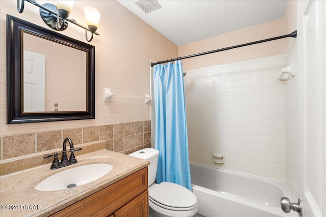 full bathroom featuring toilet, tile walls, a textured ceiling, vanity, and shower / tub combo