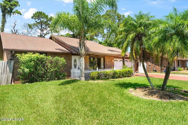 ranch-style home featuring a garage and a front lawn