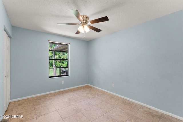 empty room with ceiling fan and a textured ceiling