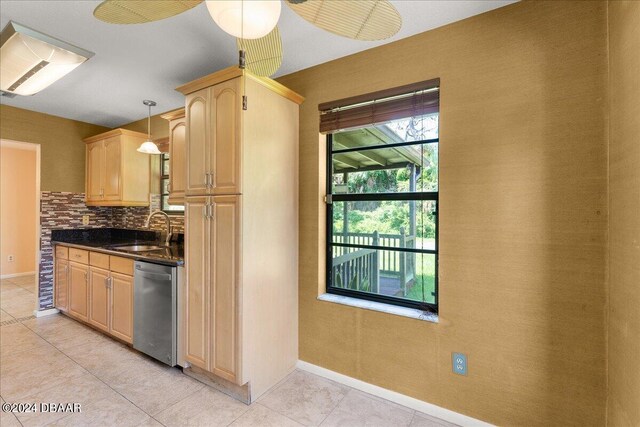 kitchen featuring sink, tasteful backsplash, light brown cabinets, decorative light fixtures, and stainless steel dishwasher