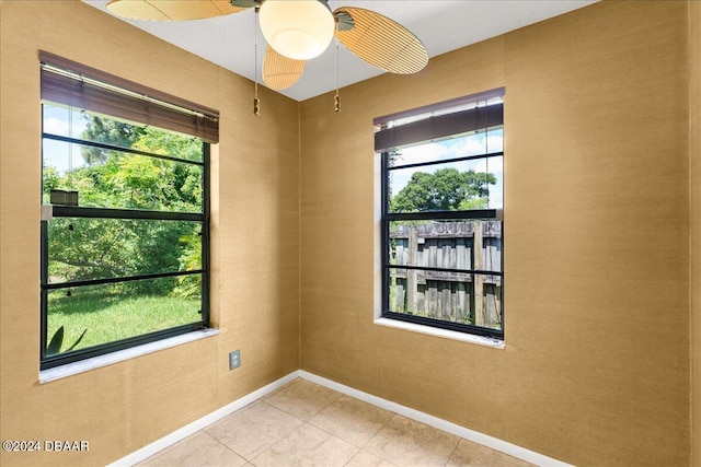 tiled spare room with ceiling fan