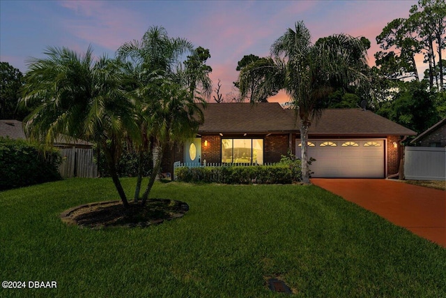 view of front of house featuring a garage and a lawn