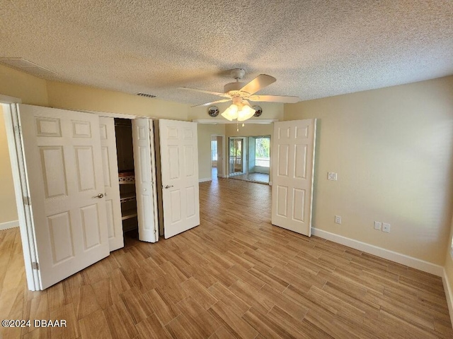 unfurnished bedroom featuring ceiling fan, a textured ceiling, and light hardwood / wood-style flooring