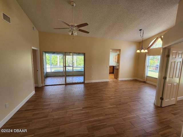 unfurnished room featuring a textured ceiling, ceiling fan with notable chandelier, dark hardwood / wood-style floors, and a high ceiling