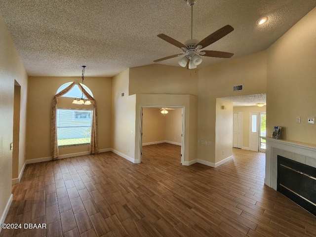 unfurnished living room with a textured ceiling, plenty of natural light, and dark hardwood / wood-style floors