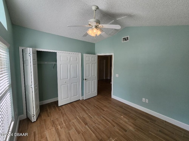 unfurnished bedroom with wood-type flooring, lofted ceiling, a textured ceiling, ceiling fan, and a closet