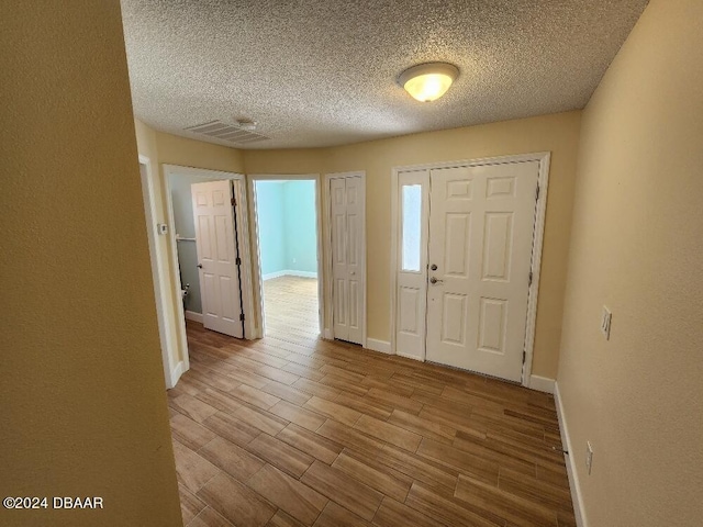 entrance foyer featuring light hardwood / wood-style floors and a textured ceiling