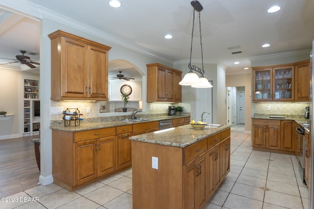 10 Foxhunter Flt, Ormond Beach, FL 32174 - kitchen with brown cabinetry, an island with sink, ceiling fan, and a sink
