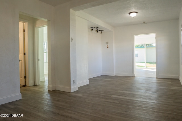 spare room featuring dark hardwood / wood-style flooring and a textured ceiling