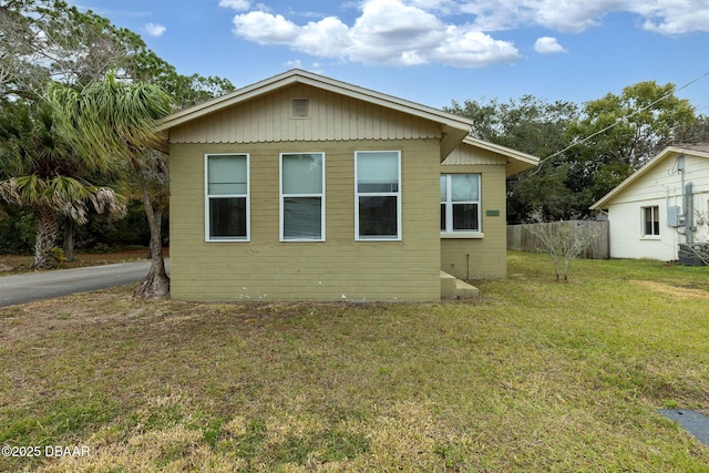 back of house with central AC and a lawn