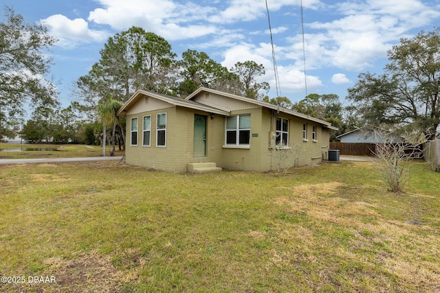 view of front facade with cooling unit and a front lawn