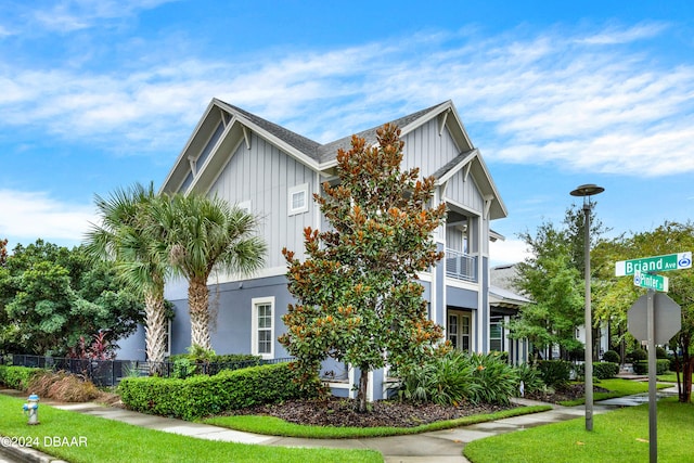 view of front of property featuring a front yard and a balcony