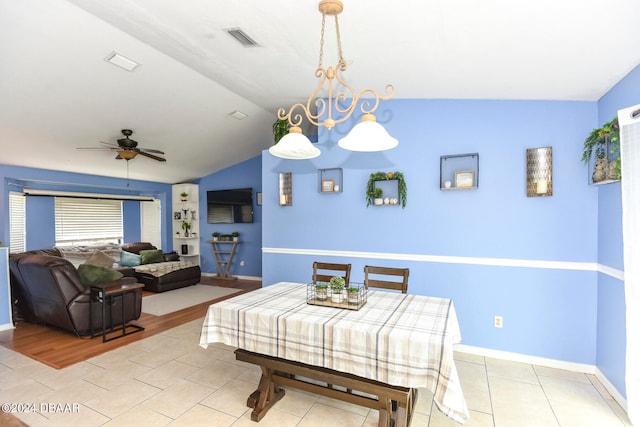 dining room with ceiling fan, light wood-type flooring, and vaulted ceiling