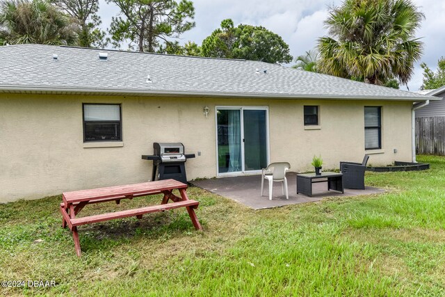 rear view of house featuring a patio area and a yard