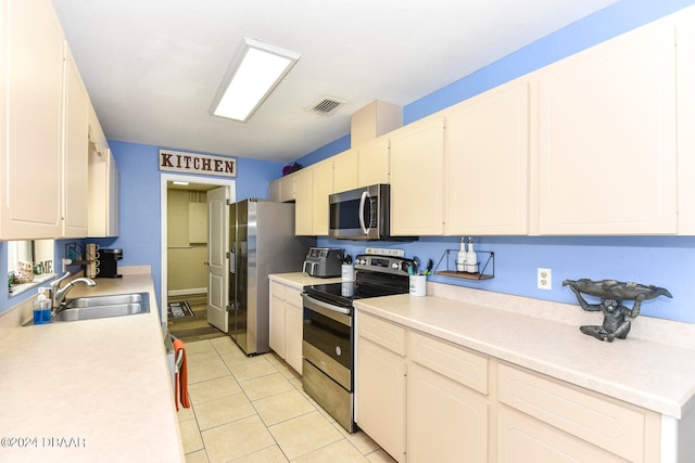 kitchen with white cabinetry, appliances with stainless steel finishes, sink, and light tile patterned flooring