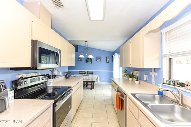 kitchen featuring light tile patterned flooring, sink, appliances with stainless steel finishes, pendant lighting, and vaulted ceiling