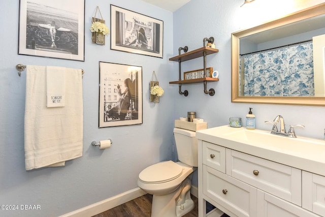 bathroom with wood-type flooring, vanity, and toilet