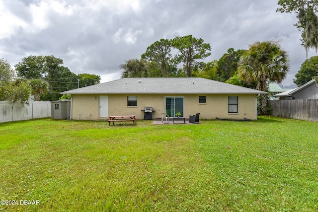 back of property featuring a lawn and a patio area