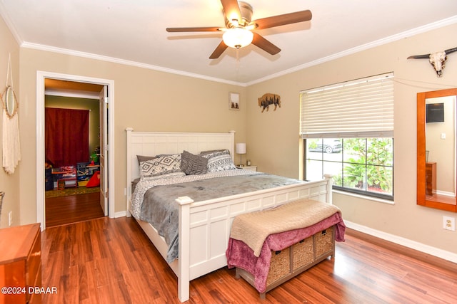 bedroom featuring dark wood-type flooring, ornamental molding, and ceiling fan