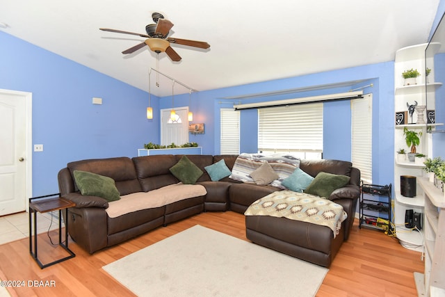 living room with lofted ceiling, ceiling fan, and light hardwood / wood-style flooring