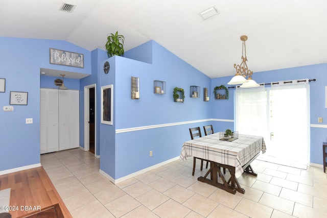 dining space featuring light hardwood / wood-style flooring, a chandelier, and vaulted ceiling