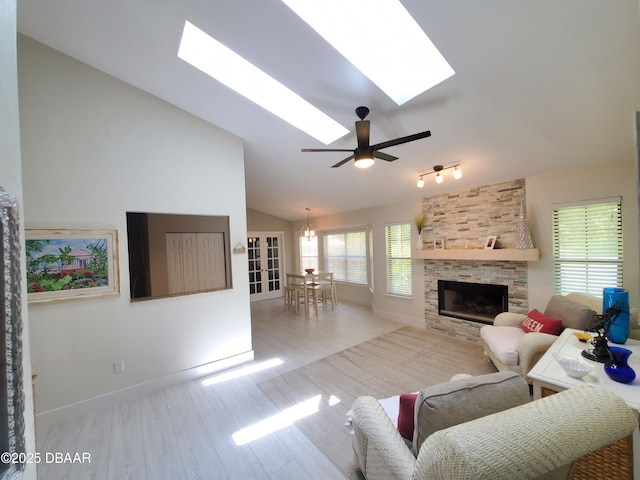1941 Spruce Creek Lndg, Port Orange, FL 32128 - living area with lofted ceiling, a skylight, wood finished floors, a stone fireplace, and ceiling fan