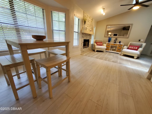 1941 Spruce Creek Lndg, Port Orange, FL 32128 - dining area featuring light wood-style floors, lofted ceiling, a ceiling fan, and a stone fireplace