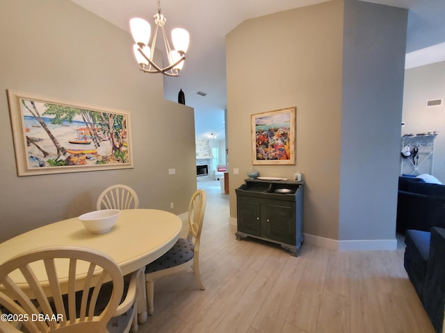 1941 Spruce Creek Lndg, Port Orange, FL 32128 - dining space featuring a chandelier, high vaulted ceiling, light wood-style flooring, and a fireplace