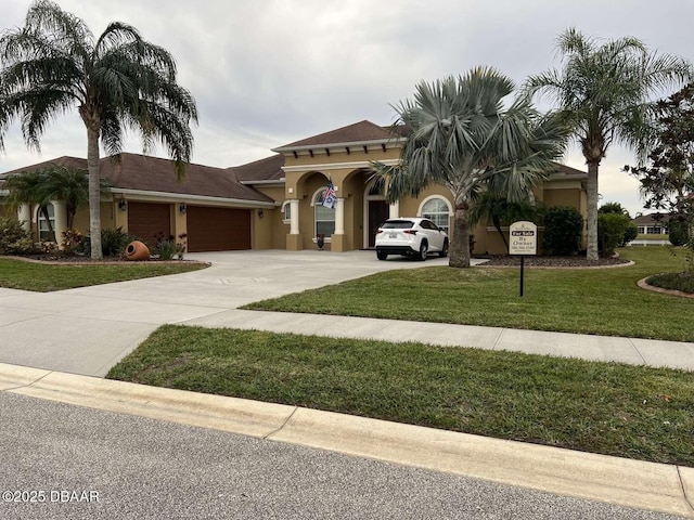 mediterranean / spanish-style house featuring a garage and a front yard