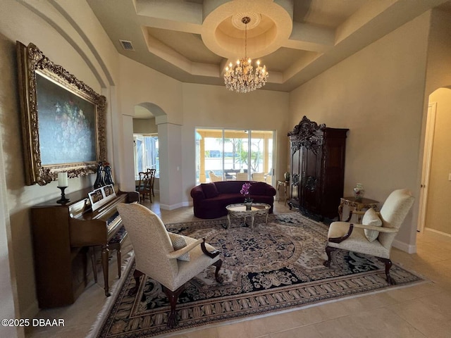 living room featuring light tile patterned floors, an inviting chandelier, a towering ceiling, and coffered ceiling